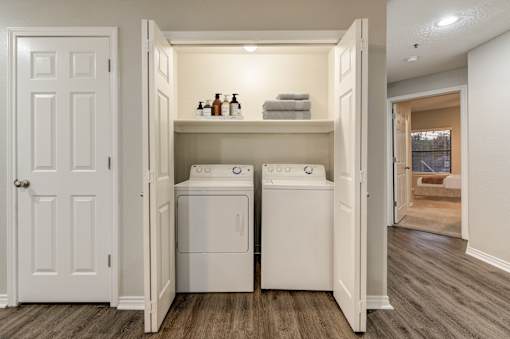 A small laundry room with a washer and dryer in it at Ashford Belmar in Lakewood, Colorado