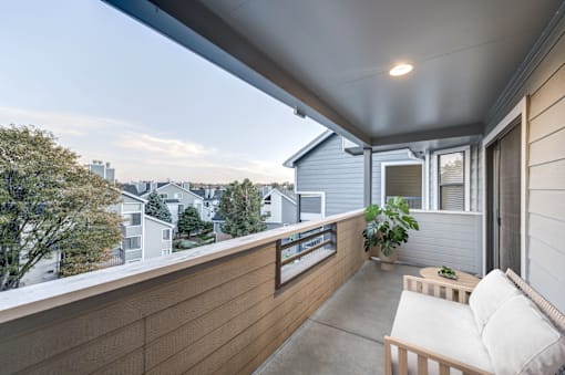 A balcony with a white couch and a potted plant at Ashford Belmar in Lakewood, Colorado 80226