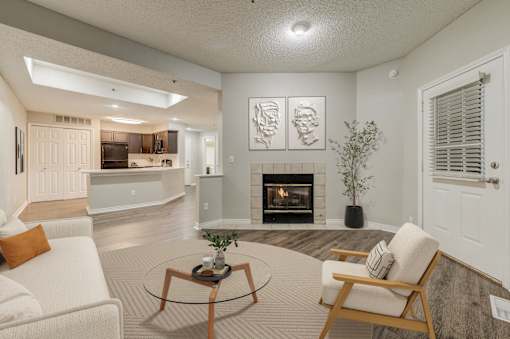 A living room with a fireplace and two chairsat Ashford Belmar in CO 80226