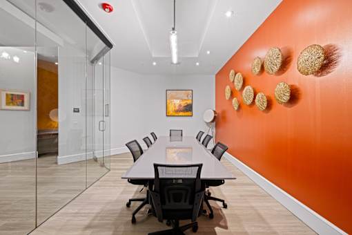 A conference room with a long table and chairs.
