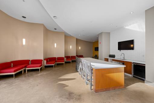 A modern kitchen with red chairs and a wooden island.