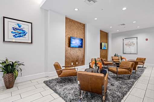 A living room with a grey rug and brown chairs.