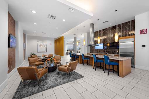A modern living room with a kitchen in the background.