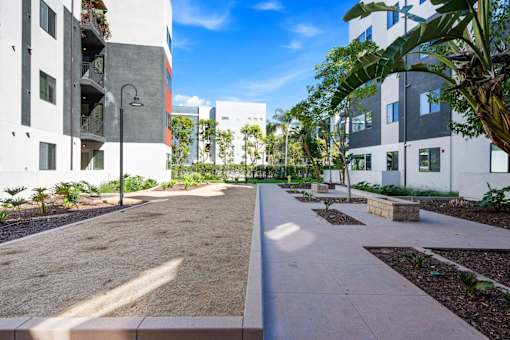 A sunny day at a modern residential area with apartment buildings and a clean, well-maintained courtyard.