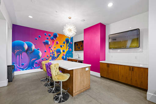 A brightly colored mural in a room with a bar and stools.
