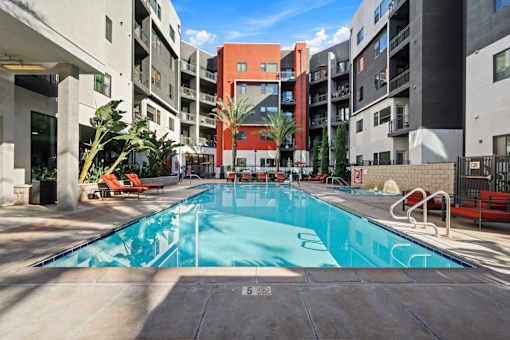 A swimming pool in a courtyard surrounded by buildings.