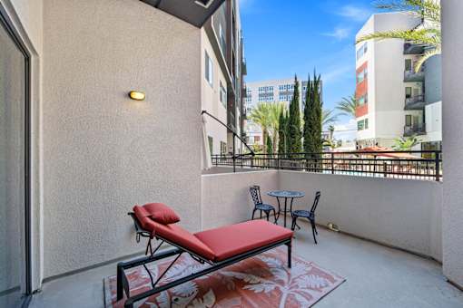 A balcony with a red couch and a table.