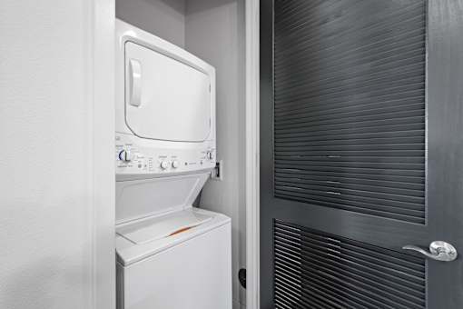 A white dishwasher is in a small kitchen.
