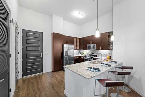 A kitchen with a white island and brown cabinets.