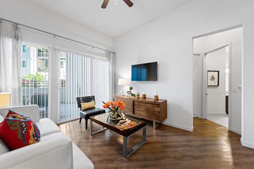 A living room with a white couch and a wooden coffee table.