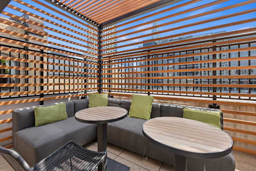A patio with a table and chairs with a view of a building.