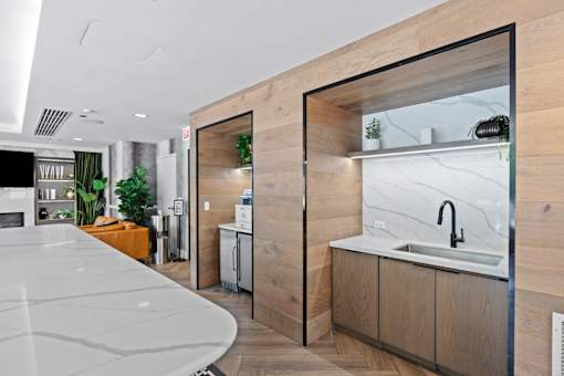 A modern kitchen with a marble countertop and wooden accents.