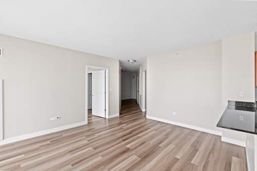 A room with wooden flooring and white walls.