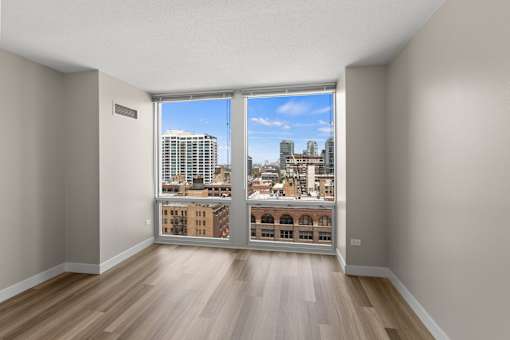 A room with a view of the city through a large window.