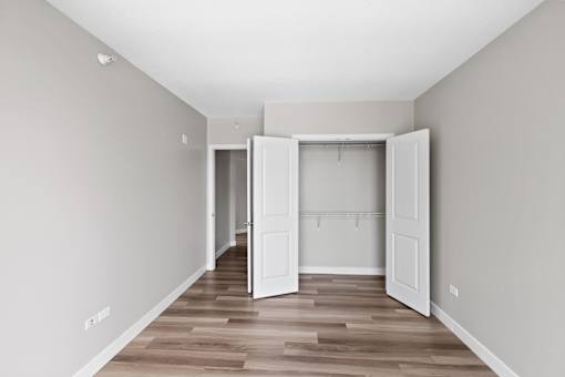 A room with a white door and a wooden floor.