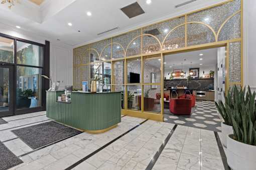 A reception area with a green counter and a gold framed glass door.