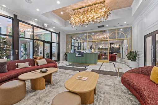 A large, well-lit room with a chandelier, sofas, and a coffee table.
