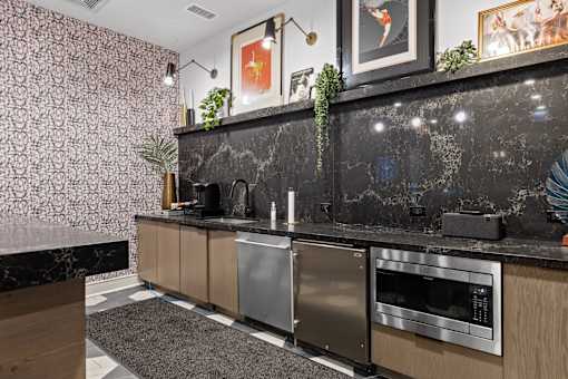 A modern kitchen with a black marble backsplash and stainless steel appliances.