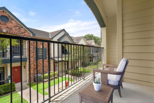 a patio with a chair and a table on a balcony