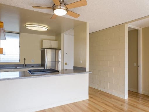 an empty kitchen with an island and a ceiling fan at Palms of Kilani Apartments, Hawaii, 96786