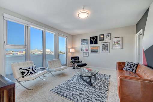 a living room with large windows and a leather couch at L Seven, California