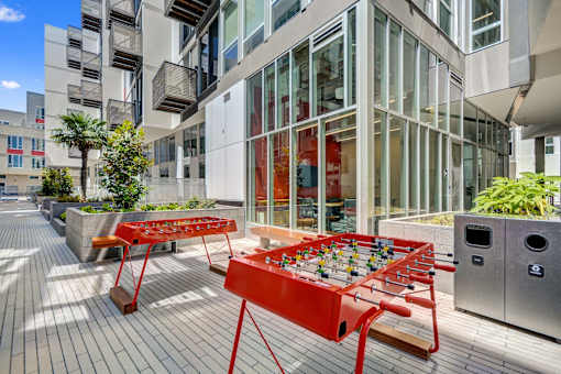 a foosball table on a patio in front of a building at L Seven, California, 94103