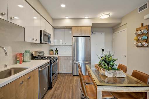 a kitchen with stainless steel appliances and a table with chairs at L Seven, California