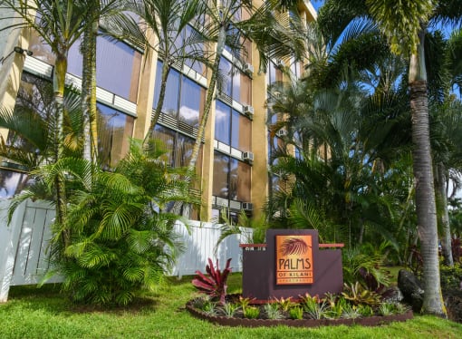 a sign in front of Palms of Kilani with palm trees at Palms of Kilani Apartments, Wahiawa, HI 96786