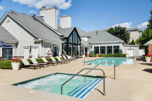 Soothing blue swimming pool with white lounge chairs at Residences at Stevens Pond, Saugus