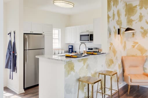 a kitchen with a marble counter top and a stainless steel refrigerator at Residences at Stevens Pond, Saugus, 01906