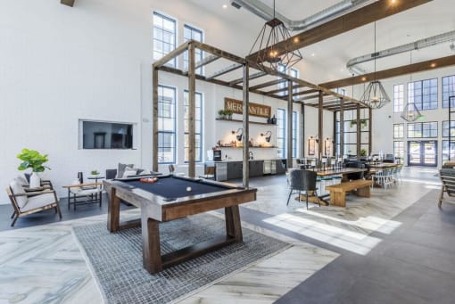 Chic resident lounge area with a pool table in the middle at The Merchant Apartments, Charleston, South Carolina