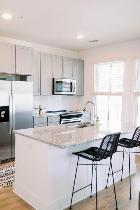 a kitchen with a marble counter top and a refrigerator at The Merchant Apartments, Charleston, SC