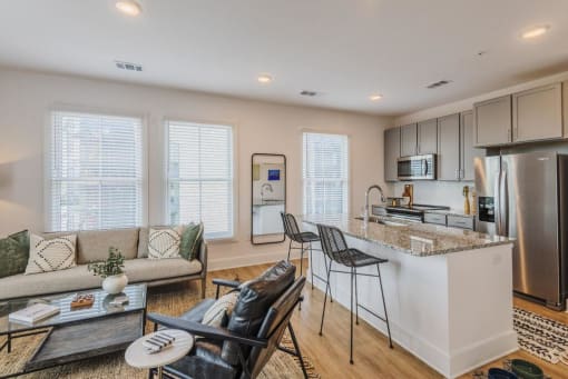 a living room with a kitchen and a table at The Merchant Apartments, Charleston