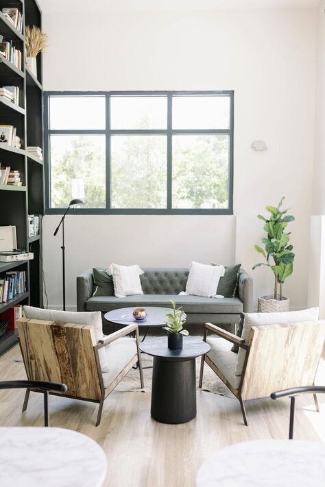 Library lounge with a couch and chairs at The Merchant Apartments, South Carolina 29403