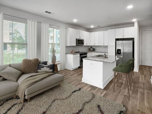 a living room with a kitchen and a couch at The Merchant Apartments, Charleston
