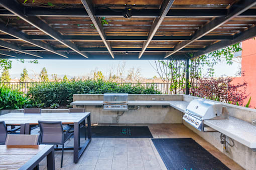 A patio with a table and chairs under a roof.