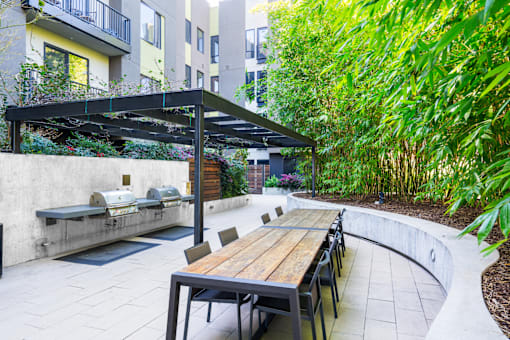A patio with a table and chairs under a roof.