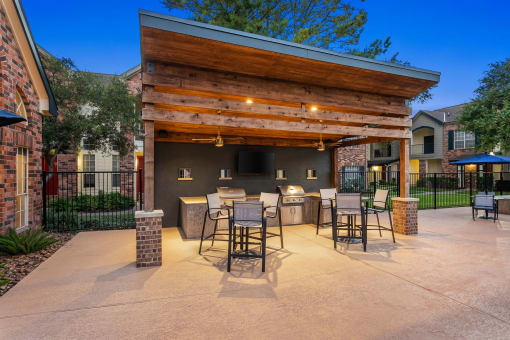 a covered patio with a bar and dining area at Aston at Cinco Ranch, Katy, 77450