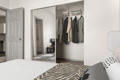 a bedroom with a bed and a closet with a mirror at Aston at Cinco Ranch, Katy, TX