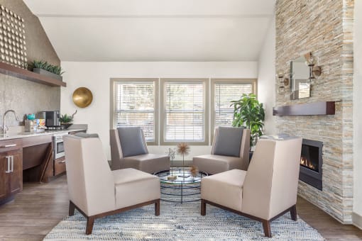 a living room with chairs and a table and a fireplace at Arcadia Apartments, Centennial