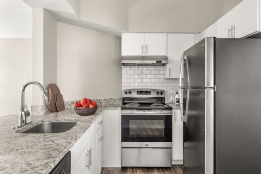 a kitchen with stainless steel appliances and granite counter tops at Arcadia Apartments, Centennial, 80112
