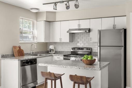 a kitchen with stainless steel appliances and a marble counter top at Arcadia Apartments, Centennial, Colorado