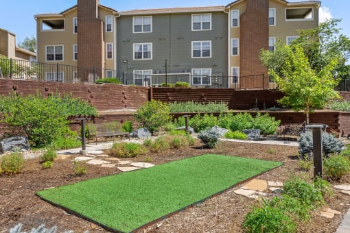 a garden with a lawn in front of an apartment building at Arcadia Apartments, Centennial, CO 80112