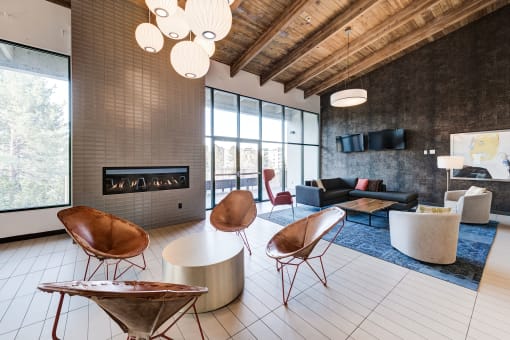 a living room with chairs and couches and a fireplace at Ashford Belmar Apartments, Colorado, 80226