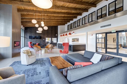a living room with couches and chairs and a fireplace at Ashford Belmar Apartments, Lakewood, Colorado