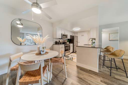 a dining area with a table and chairs and a kitchen in the background  at Citrine Hills, Ontario, CA, 91761