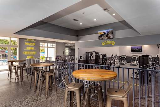 A restaurant with tables and chairs and a bar area.