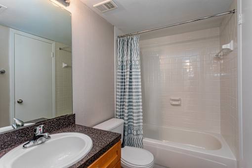 A bathroom with a sink, toilet, and bathtub.