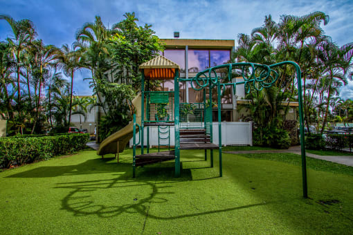 a playground with a slide and a swing at Palms of Kilani Apartments, Hawaii