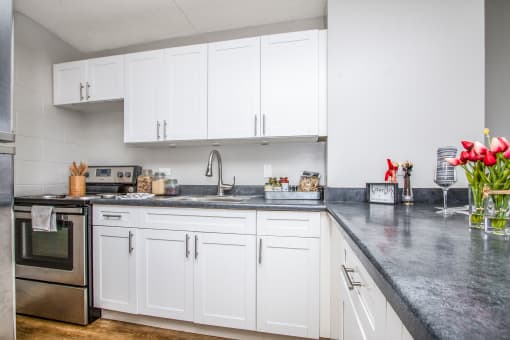 a white kitchen with marble counter tops and white cabinets at Waikele Towers Apartments, Waipahu, HI 96797